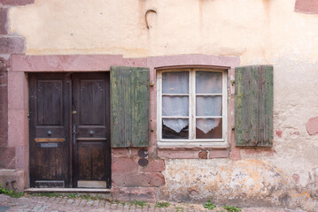 Façade d'une vieille maison alsacienne à Riquewihr. Ancienne maison avec une fenêtre et une porte en bois. Maison rustique. Alsace