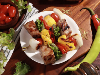 Barbecue grilled sliced ​​meat and vegetables on a wooden table