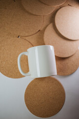 White cup with cork coasters on a light background