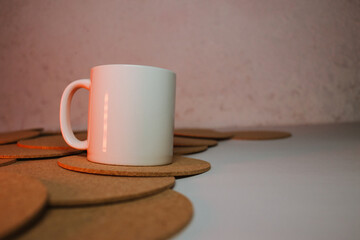 White cup with cork coasters on a light background