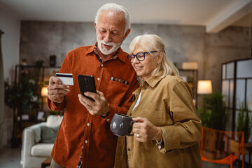 senior husband and wife shop online on mobile phone with credit card