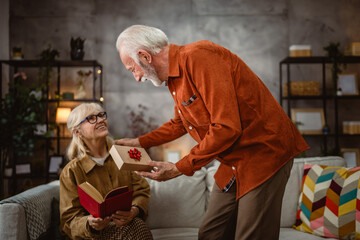 Senior husband surprise his senior wife with gift box while at home