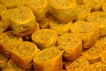 Close-up view of baklava with pistachios, walnuts and cream in a dessert shop selling traditional Turkish desserts. Şöbiyet, nightingale's nest, bird's eye baklava. Turkish culinary delights. Dessert 