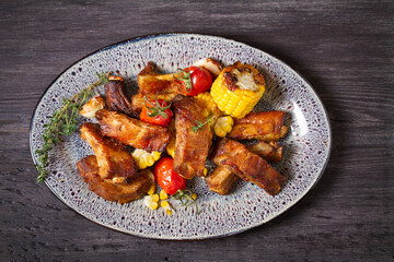 Barbecue grilled pork spare ribs with vegetables on a plate. High angle view