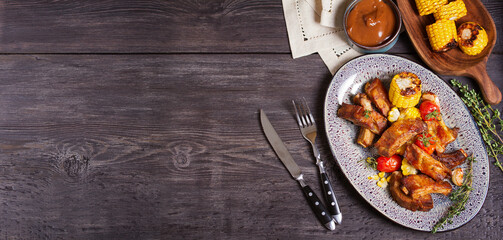 Barbecue grilled pork spare ribs with vegetables on wooden background with a copy space. High angle view