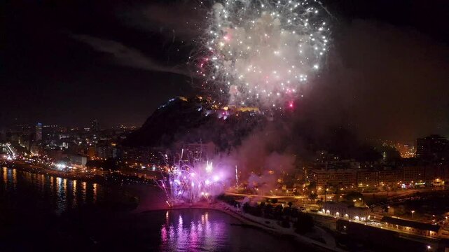 Nocturne aerial view of the fireworks launched in the beach of El Postiguet, in the Mediterranean city of Alicante, Spain.