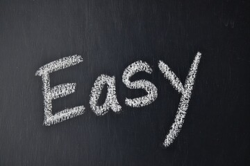Blackboard with the word Easy written in chalk, symbolizing simplicity and straightforwardness in learning or tasks.
