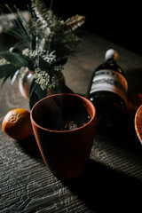 Craft Cup of Mulled Wine With Tangerine and Wine Bottle in Cozy Setting Perfect for Winter Gatherings