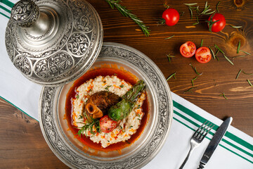 Traditional Turkish cuisine dish Lamb Shank with sauce. Lamb shank served elegantly on a copper plate.