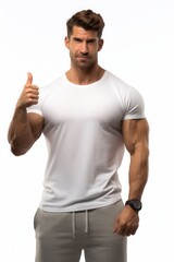 Naklejka premium Muscular man in a white shirt shows thumbs up for fitness encouragement and healthy lifestyle