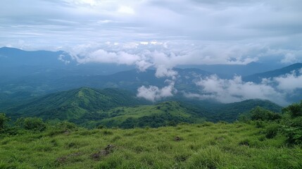 Stunning panoramic view from a mountain peak showcasing lush green landscapes and dramatic cloud formations in a serene natural setting