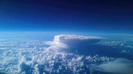 Striking aerial view of dense cumulonimbus clouds showcasing fluffy white and gray formations against a deep blue sky.