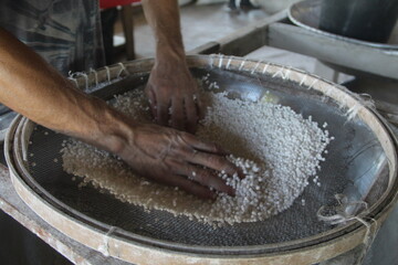 pessoa peneirando farinha de mandioca em cruzeiro do sul, no acre 