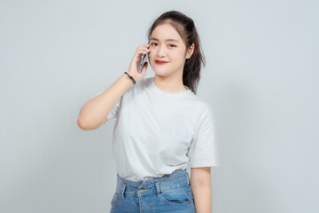 A portrait of a cheerful Asian woman directing the phone to his ear, meaning he was making a call