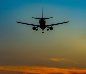 A plane is currently flying beautifully in the sky at sunset time