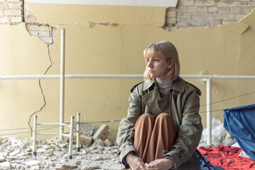 A woman near a house destroyed by the war. War in Ukraine.