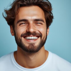 Obraz premium A young man with casual t-shirt is smiling at the camera, solid color background