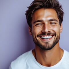 Obraz premium A young man with casual t-shirt is smiling at the camera, solid color background