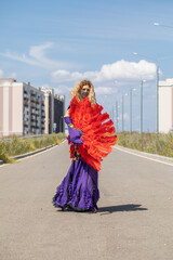 Naklejka premium Sexy beautiful woman in a purple costume dances on the street