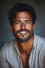 Obraz premium Handsome man with a warm smile and tousled hair exudes confidence against a neutral backdrop in a casual shirt