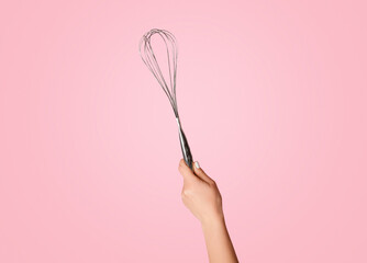 Closeup of millennial girl showing whisk on pink background