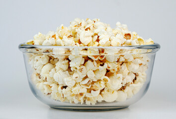 Delicious freshly popped popcorn in a clear glass bowl