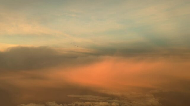 An immersive piulot&rsquo;s perspevtive POV FPV in a real time flight through golden ethereal clouds recorded from a jet cockpit at sunrise. 4K 60FPS