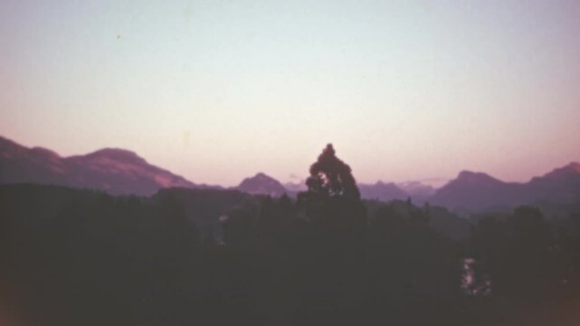 Romantic sunset over the Swiss mountains, featuring warm red tones in a serene natural setting. A calming and timeless alpine scene from the 1950s. Color 4K archival footage.