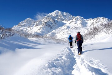 Two snowshoers navigating a snow-covered trail, experiencing the serene beauty of winter landscapes surrounded by towering peaks and untouched snow.