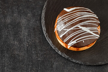 sweet bun with chocolate and white icing, selective focus
