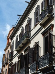 Elegant balconies and windows of black colour with metallic railings on the street of Cagliari, Italy. Vertical photo