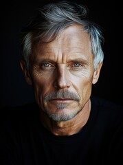 Fototapeta premium A portrait of an older, attractive man with grey hair and a goatee