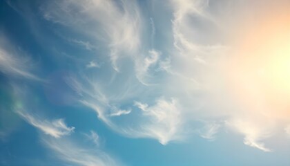 Fototapeta premium A clear blue sky with swirling, wispy white clouds, showcasing the transition from day to evening with a soft gradient.