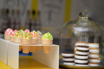 Homemade marshmallows in cups and cakes with cookies in the window
