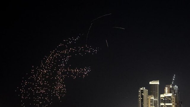 Drone show in night sky over Bluewaters and JBR Beach promoting Dubai Shopping Festival. Taken from hands. High quality 4k footage