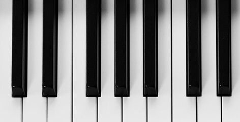 Naklejka premium Piano keyboard with black and white keys, top view. Banner design