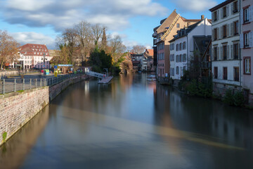 Naklejka premium Scenic view of a calm canal surrounded by historic buildings in Strasbourg.