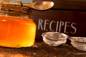 Scene of golden jar of honey with a recipe box in the background