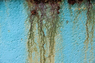 The steel wall is very old, rusted, peeled, cracked and dirty.