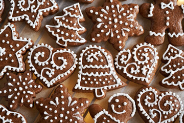 Homemade gingerbread Christmas cookie decorated with white icing on illuminated baking paper