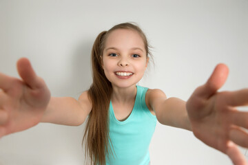 The girl stretches her arms for a hug. Wide angle