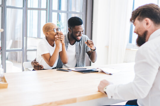 Happy black couple with estate agent