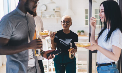 Sociable friends chilling with alcohol and snacks