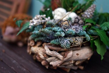 Green Arrangement with Wooden Hedgehog Decor.  natural green arrangement made of branches,...