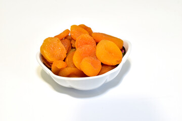 Dried apricots, dried apricots, in a deep plate on a white background.