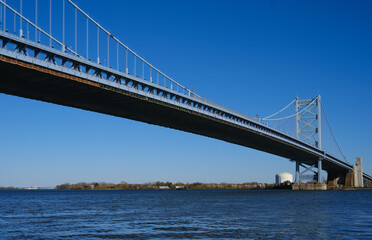 The Ben Franklin Bridge built in 1926 spanning between Philadelphia PA and Camden New Jersey on a beautiful blue sky afternoon