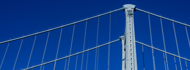 Obraz premium Panoramic image ofThe Ben Franklin Bridge towers built in 1926 spanning between Philadelphia PA and Camden New Jersey on a beautiful blue sky afternoon