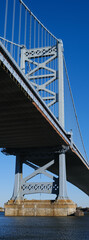 The Ben Franklin Bridge built in 1926 spanning between Philadelphia PA and Camden New Jersey on a beautiful blue sky afternoon