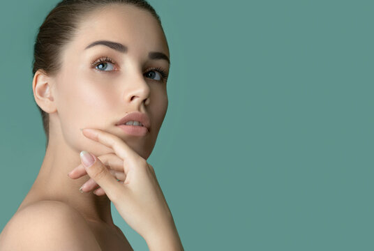 Beautiful young women face with perfect fresh skin and makeup. Portrait of model with make-up, formed eyebrows  and long eyelashes. Beauty and Spa, skincare and wellness. Selective focus.