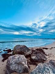 rocks on the beach and amazing clouds over the sea